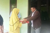 Gambar: Camat Mangoli Timur Kisman Duwila, menyalurkan Bantuan Sembako dari Bupati Kepulauan Sula, Hj. Fifian Adeningsi Mus, kepada Masyarakat Desa Naflow.
